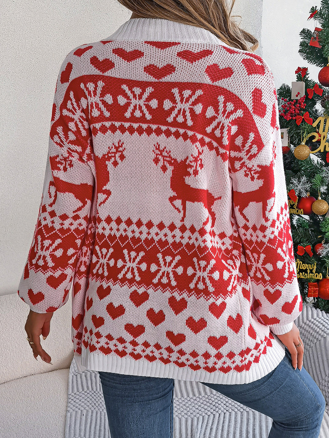 Vrouw in rood gebreid kerstvest met rendieren